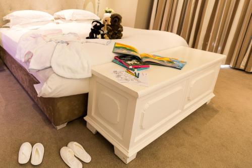 a bedroom with a bed with a table with shoes at The Cellars-Hohenort in Cape Town