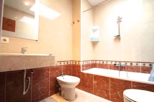 a bathroom with a toilet and a tub and a sink at Narcis, Atico en El Tarter, Zona Grandvalira in El Tarter