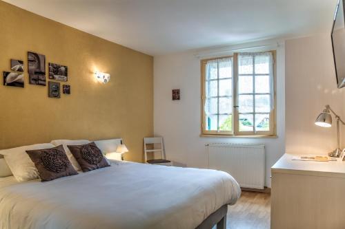 a bedroom with a large bed and a window at Hôtel Restaurant du Commerce in Estang