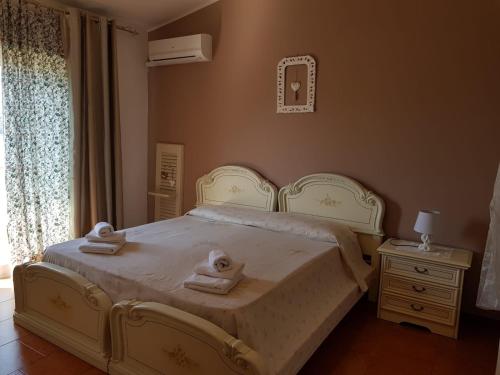 1 dormitorio con 1 cama con toallas en B&B Mirasol, en Scalea