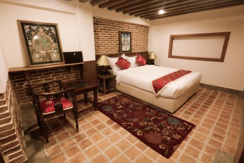 Habitación de hotel con cama, mesa y cama sidx sidx en Heranya Yala en Katmandú