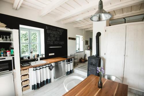 cocina con mesa de madera y pared negra en Noemi's Cottage en Balatongyörök