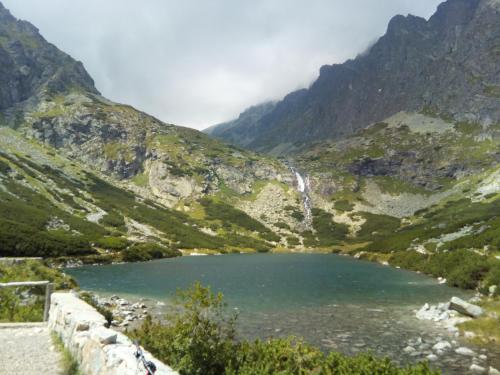a mountain lake with a waterfall in a valley at Apartment Eric 9D High Tatras in Vysoké Tatry