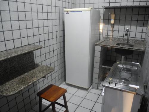 a small kitchen with a refrigerator and a sink at Praia Apart Hotel in Natal