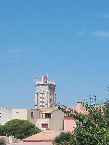 a building with a tower with canadian flags on it at Appartement Pérols Centre in Pérols
