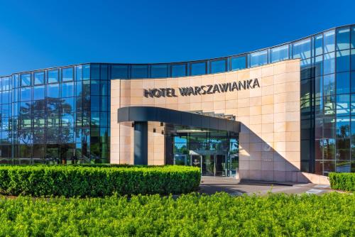 a building with a sign on the front of it at Hotel Warszawianka in Jachranka