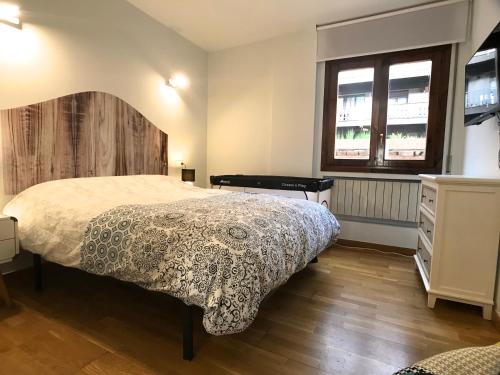 a bedroom with a bed and a dresser and two windows at Poblat Andorrá, Encamp, con terraza, zona Grandvalira in Encamp