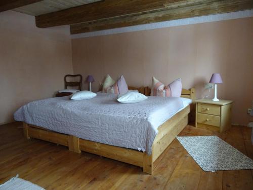 - une chambre dotée d'un grand lit avec des draps blancs et des oreillers roses dans l'établissement Urselhof, à Hermsdorf