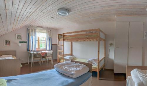 オーシャにあるVandrarhemmet i Fredshammarの二段ベッド2台とテーブルが備わる客室です。