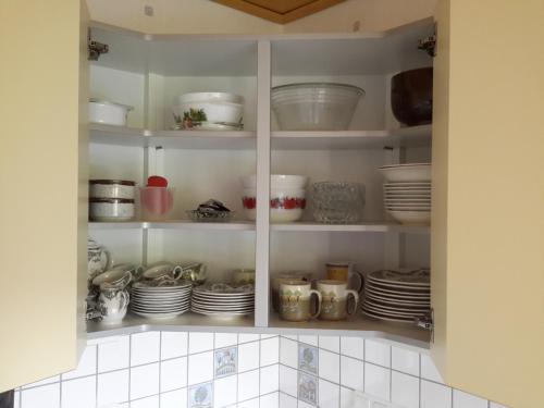 a cupboard filled with dishes and plates in a kitchen at Ferienwohnung Karin Vogel in Hilchenbach