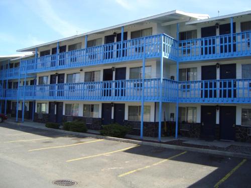 an apartment building with blue balconies and a parking lot at Willow Springs Motel in Cheney