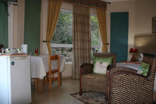 a room with a table and chairs and a window at Villa-Candilabra Guesthouse in Komatipoort