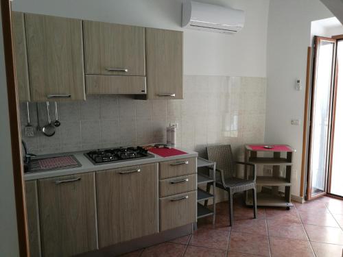 a kitchen with wooden cabinets and a table and a stove at Appartamento Tripoli in Vieste