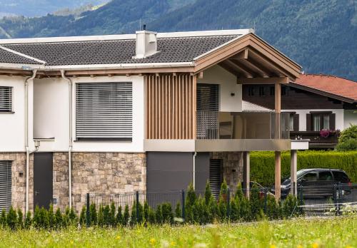 a house with a car parked in front of it at Aurora Mountain Chalet by we rent, SUMMERCARD INCLUDED in Kaprun