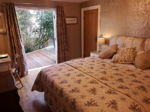 a bedroom with a bed and a door to a deck at The Curate's Quarters at the Old Vicarage in Lincoln