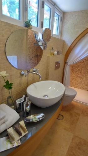 a bathroom with a sink and a toilet and a mirror at La Closerie in Droue-sur-Drouette