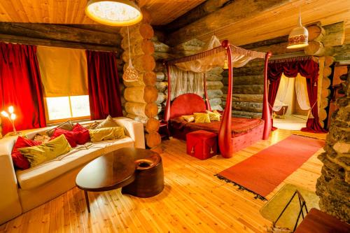 ein Wohnzimmer mit einem Sofa und einem Bett in der Unterkunft Kakslauttanen Arctic Resort - Igloos and Chalets in Saariselkä