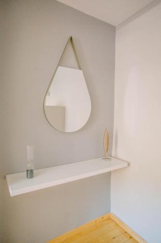 a mirror on a wall with a white shelf at Teatro Villa in Kato Rodini