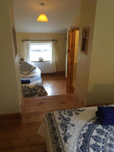 two beds in a room with a window at Restored School Master’s House in Valentia Island