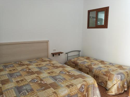 a bedroom with two beds and a window at Appartamento Tripoli in Vieste