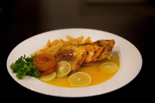 a plate of food with chicken and french fries at Villa Crystals in Colombo