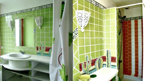 a green tiled bathroom with a sink and a mirror at Les Flots De Ma Vie Chambres D Hotes et tipi Florence Et Virginie Gossin in Barzan