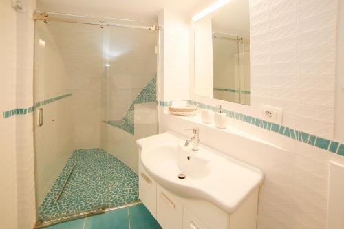 a white bathroom with a sink and a shower at Amalfi Dream Charming House in Scala