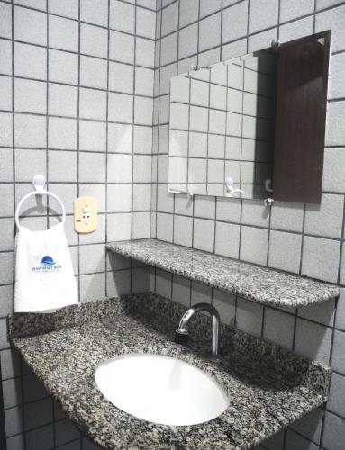 a bathroom with a sink and a mirror at Praia Apart Hotel in Natal