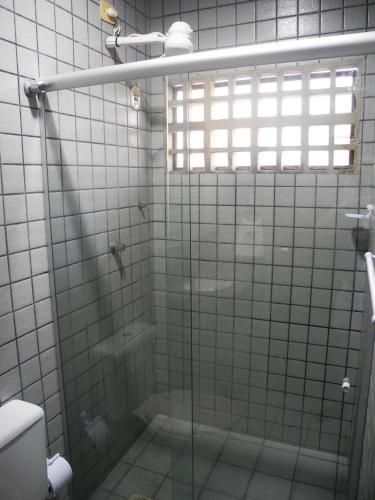 a bathroom with a glass shower with a toilet at Praia Apart Hotel in Natal