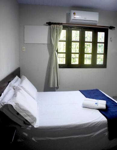 a white bed in a room with a window at Praia Apart Hotel in Natal