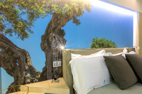 a bedroom with a tree mural on the wall at Terra d'Acqua Resort & SPA in Torre Mozza