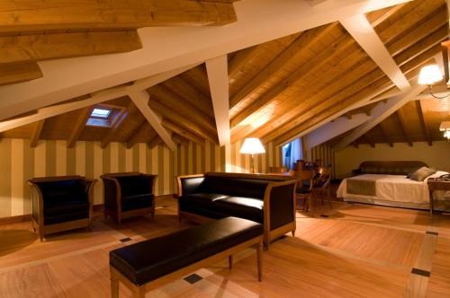 a bedroom with a bed and a couch and chairs at Hotel Villa Del Sogno in Gardone Riviera