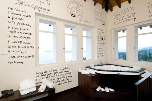 a bathroom with a tub with writing on the wall at Hotel Villa Del Sogno in Gardone Riviera