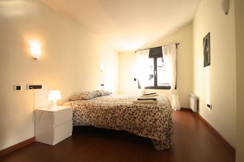 a small bedroom with a bed and a window at Prat del Tirader, Atico en Encamp, Zona Grandvalira in Encamp