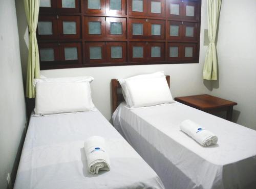 two beds in a room with towels on them at Praia Apart Hotel in Natal