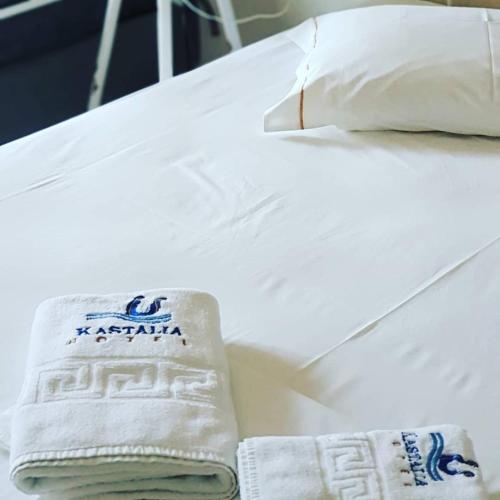 a white bed with two towels on it at Kastalia in Ammouliani