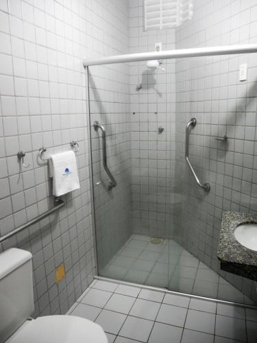 a bathroom with a shower with a toilet and a sink at Praia Apart Hotel in Natal