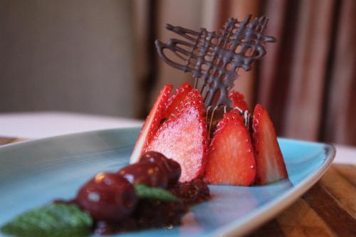 a blue plate with fruit and berries on a table at Erinvale Estate Hotel & Spa in Somerset West