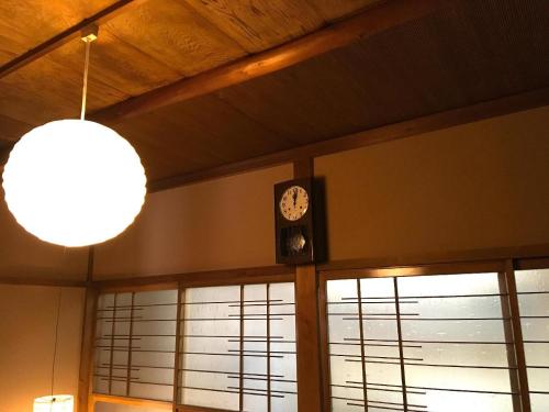 a clock on the wall of a building with windows at Fuji House in Takayama