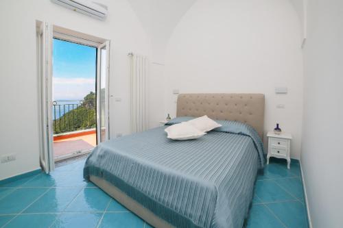 a bedroom with a bed and a large window at Amalfi Dream Charming House in Scala
