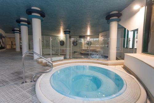 Un baño grande con bañera de hidromasaje en un edificio. en Ondamar Hotel Apartamentos, en Albufeira