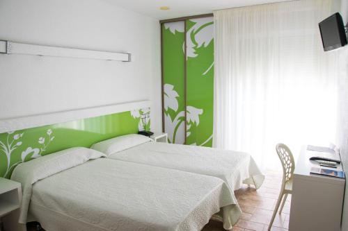 1 dormitorio con cama blanca y pared verde en Pension Agadir en San José