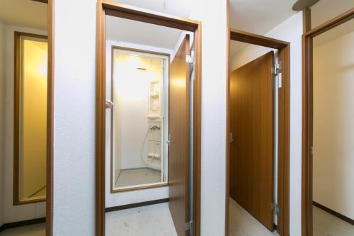a bathroom with a door and a mirror at Hotel Shin-Imamiya in Osaka