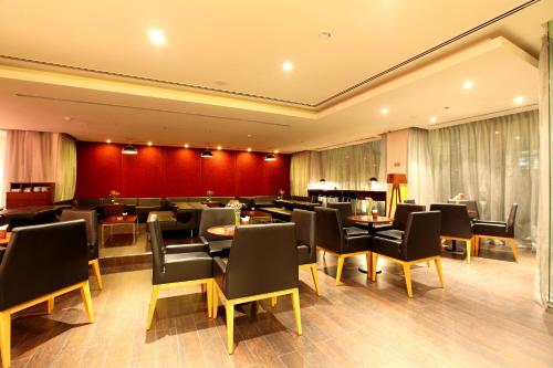 a restaurant with tables and chairs in a room at Liberty Central Saigon Centre Hotel in Ho Chi Minh City