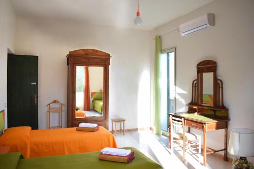 a bedroom with an orange bed and a dresser and a mirror at Giardinello Stagnone Sunset in Marsala
