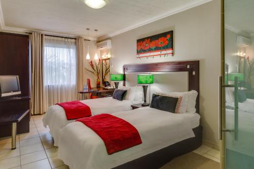 a hotel room with two beds and a television at BON Hotel Empangeni in Empangeni