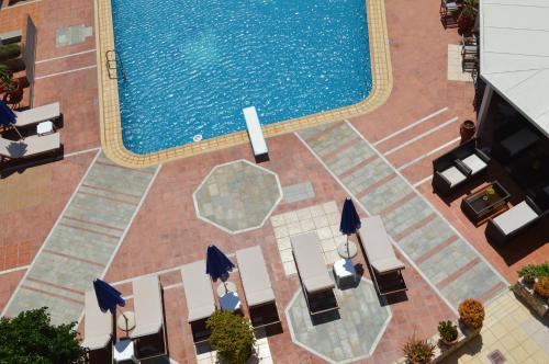 
a patio area with a pool, chairs and tables at Christina Beach Hotel in Kissamos
