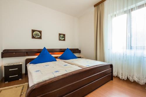 a bedroom with a bed with blue pillows and a window at Apartment Nevija e Natale in Opric