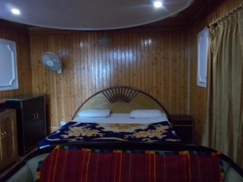 a bedroom with a bed in a wooden wall at Mall road Stay with In-house restaurant in Nainital