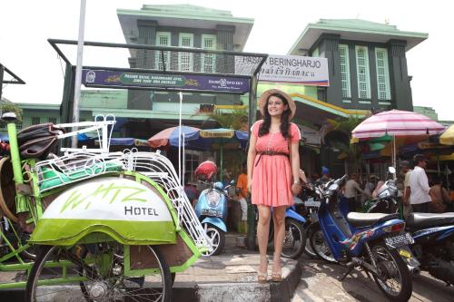 a woman in a dress standing next to a rickshaw at Whiz Hotel Malioboro Yogyakarta in Yogyakarta